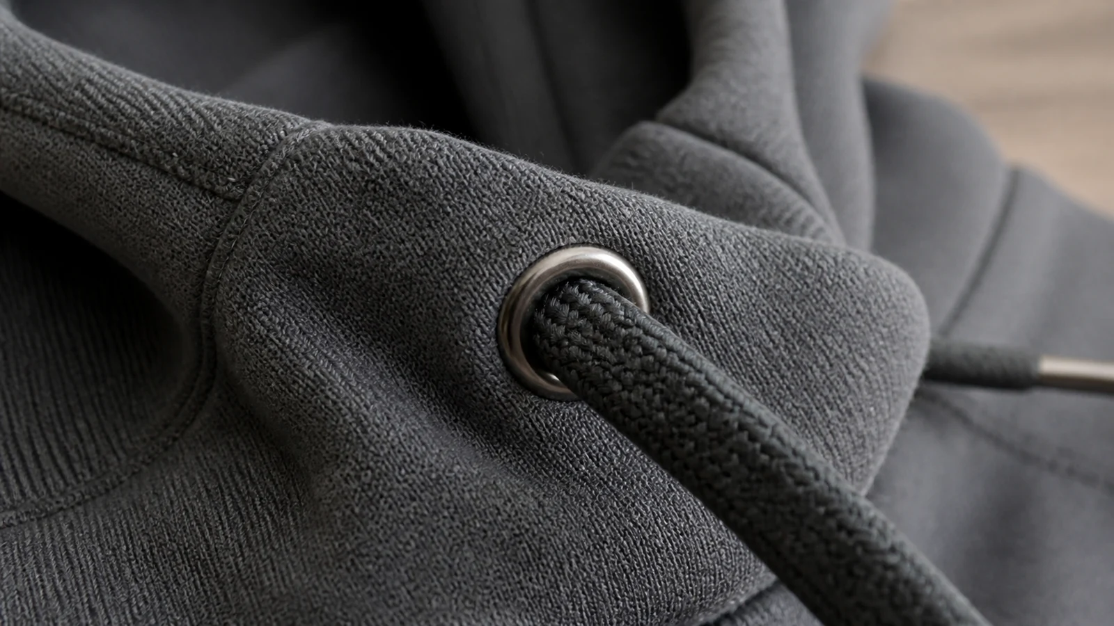 Metal eyelet installed in hoodie fabric with the drawstring passing through it